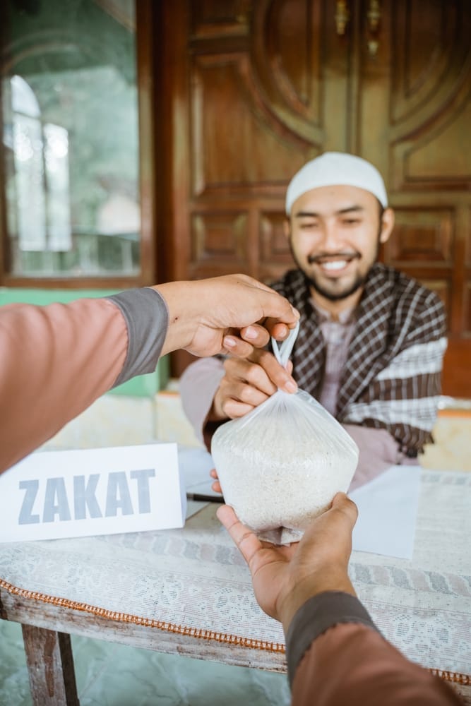 Man,Giving,A,Rice,As,A,Food,Donation,For,Zakat