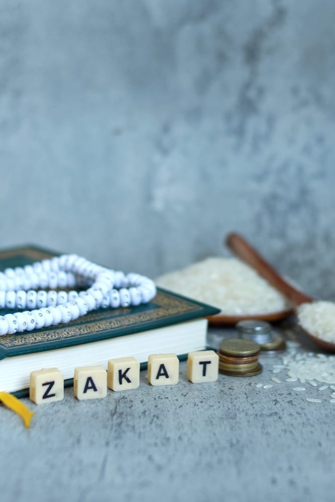 White,Cubes,With,Text,Zakat,,Coins,Stacked,And,Prayer,Beads.